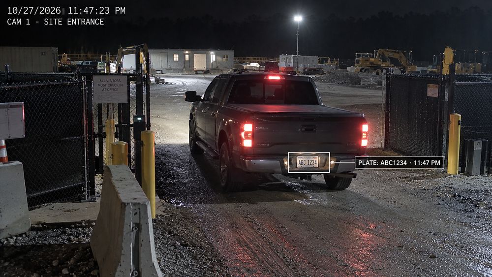 Camera still of a pickup truck at a site gate at night with an automatic license-plate capture overlay